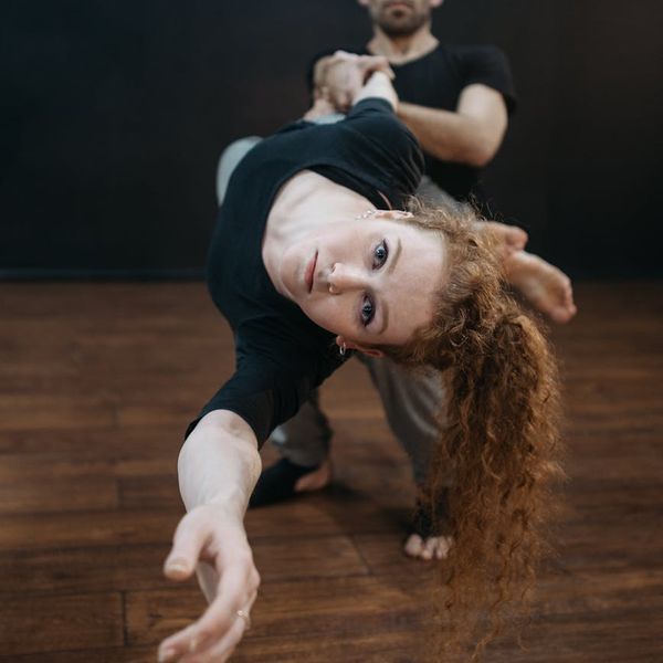 Athletic man in a dynamic pose showing strength and focus in a bright studio.